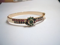 9ct yellow gold hinge bangle set with emeralds, blue sapphires and rubies taken from old jewellery supplied by the customer