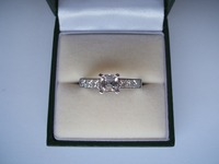 18ct white gold ring set with Asscher cut centre stone and princess cut diamonds on the shoulders