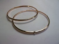 Set of two simple red gold slave bangles with white gold detail