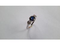 Platinum three stone ring set with centre blue sapphire and two brilliant cut diamonds.